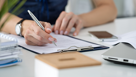 Woman filling out forms at her desk