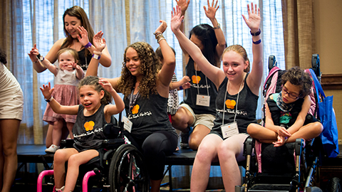 An image of children in a hospital setting, hands raised in a joyous moment.