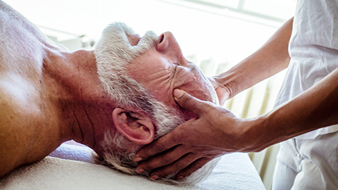 Senior man receiving cranial massage.