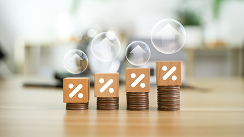 Percentage symbol for interest rate increase on pile of coins