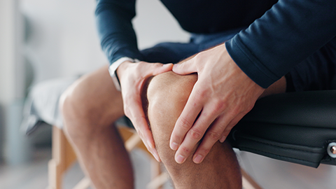 Image of a person holding their knee.