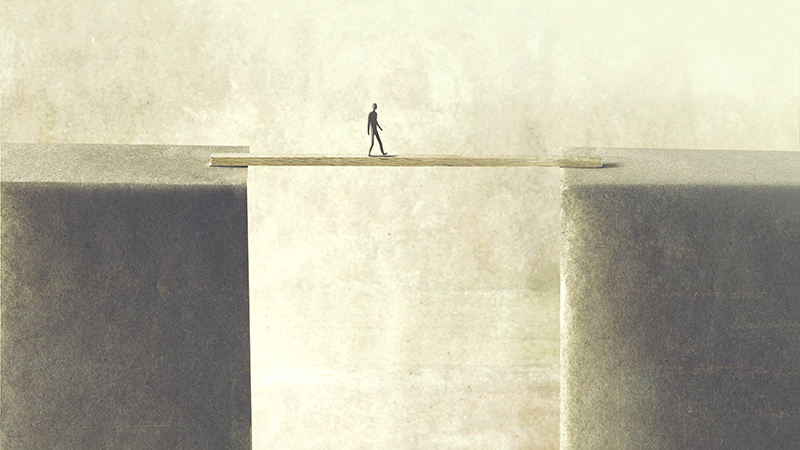 man walking on a tiny bridge.