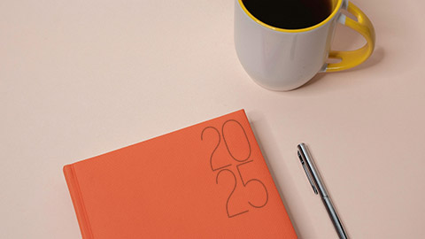 Image of a 2025 planner and cup of coffee.