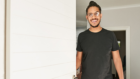 image of a person standing in a doorway smiling.