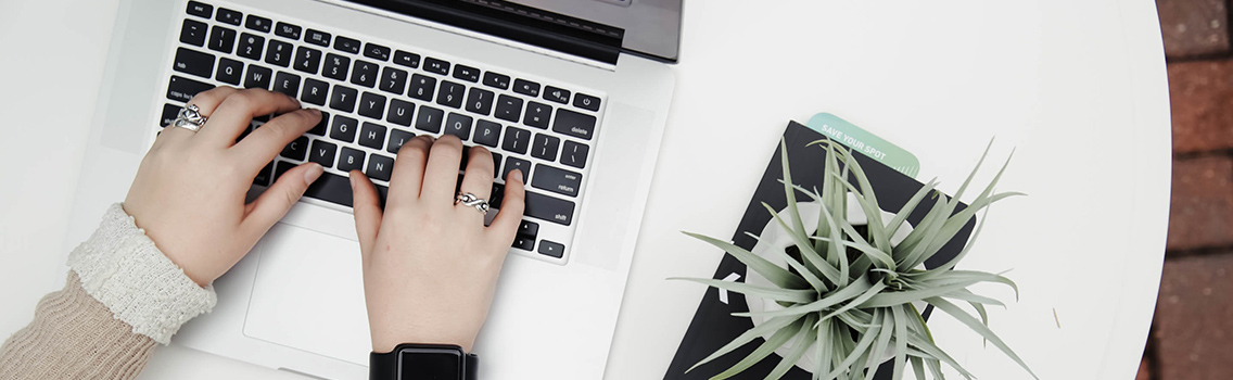 close-up, overhead shot of a woman's hands typing on a laptop by Corinne Kutz via unsplash