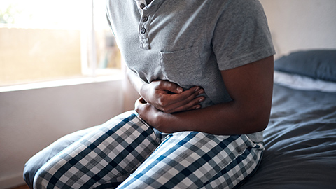 Man with stomach pain holding his stomach with both arms