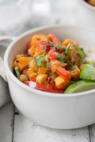 A bowl of vegeterian yellow curry with chick peas, avocados, and rice