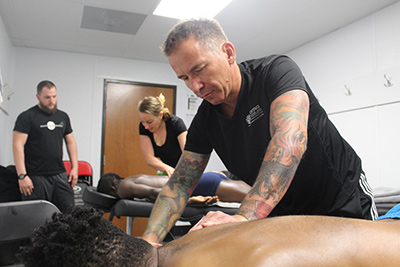 Cortiva Institute Graduates Marc Marlowe and Amy Eberbach perform massage on two Phoenix Rising players