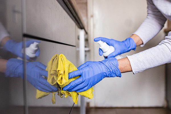 Cleaning a surface with a spray bottle and towel 