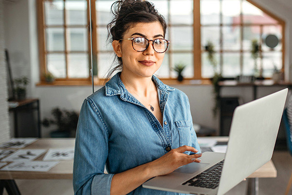 Smiling massage therapist with a laptop. 