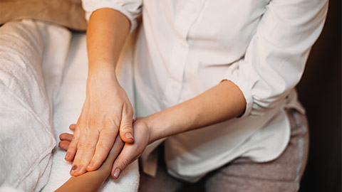 Image of a massage therapist working on a clients hand.