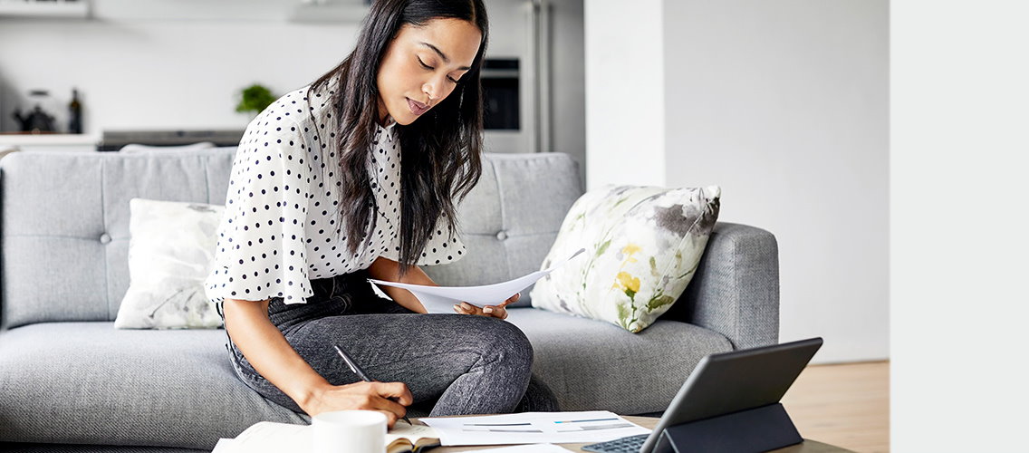 woman writing on paper on a coffee table