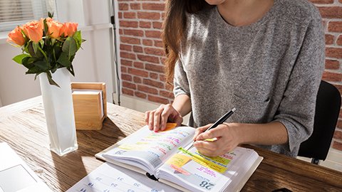 A woman sitting at a desk with an appointment book