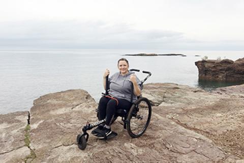 Erica Ladenthin posts for a picture on a cliff overlooking water.