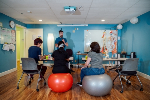 Massage therapy instructor Michael Jacobus teaches a class of three students.