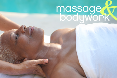 A Black woman lays supine while receiving massage near her neck and shoulders.