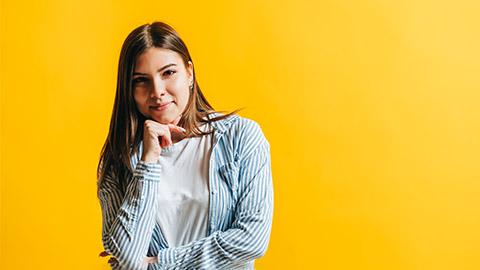 Image of a person standing against a yellow background.