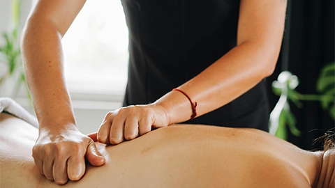 Image of a massage therapist working on a clients back.