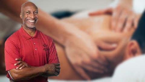 Sports massage therapist Benny Vaughn in foreground and client receiving a massage in background.