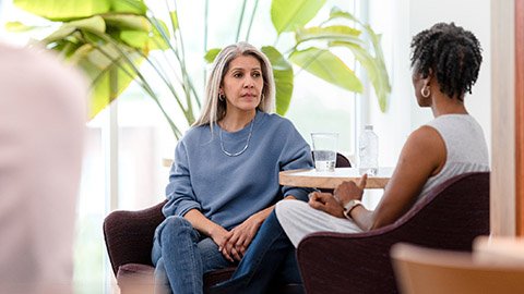 Two women sitting side-by-side in deep conversation.