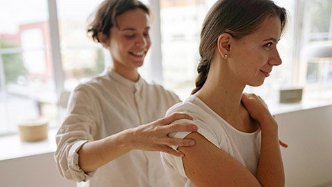 A massage therapist giving treatment to a patient.