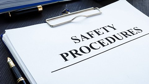 A report titled "Safety Procedures" on a clipboard