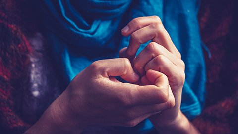 Hands picking at the skin around the nails. 