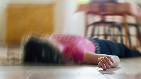 Distorted image of a person lying on a kitchen floor